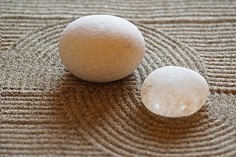 zwei runde Steine auf Sand