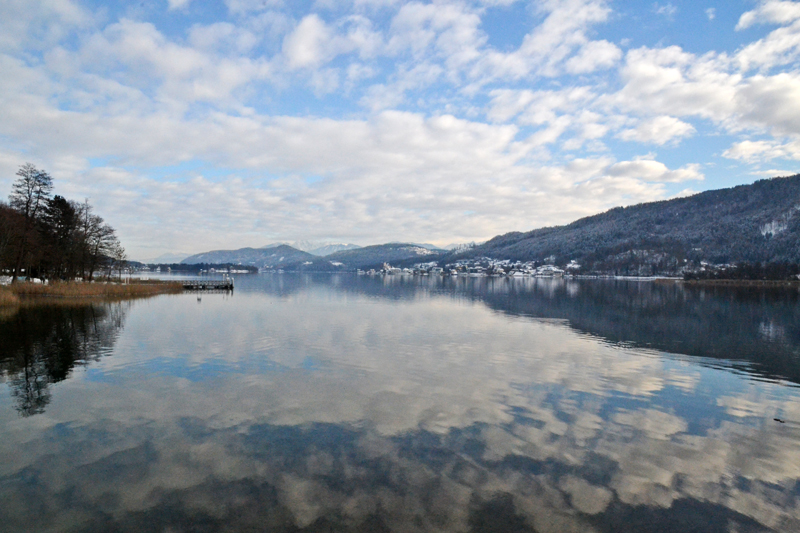 Die Wolken und der blaue Himmel spiegeln sich im Wasser des Sees